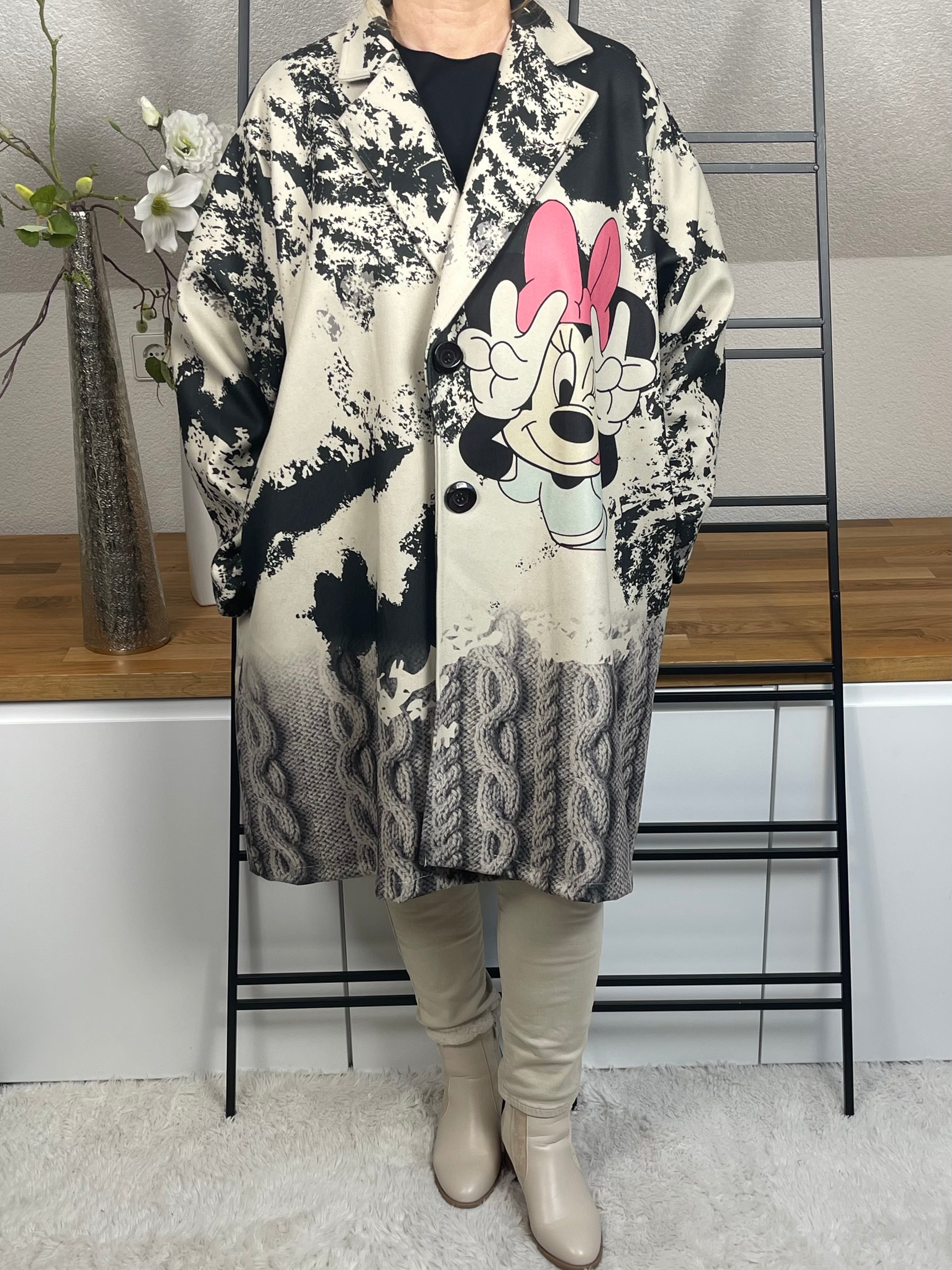 Frontansicht des „Mickey - Mouse“Oversize-Mantels aus Velour-Optik mit 50 % Wollanteil, buntem Mickey-Maus-Motiv, praktischen Taschen und schwarzen Knöpfen zum Schließen,in grau-schwarz-bunt
