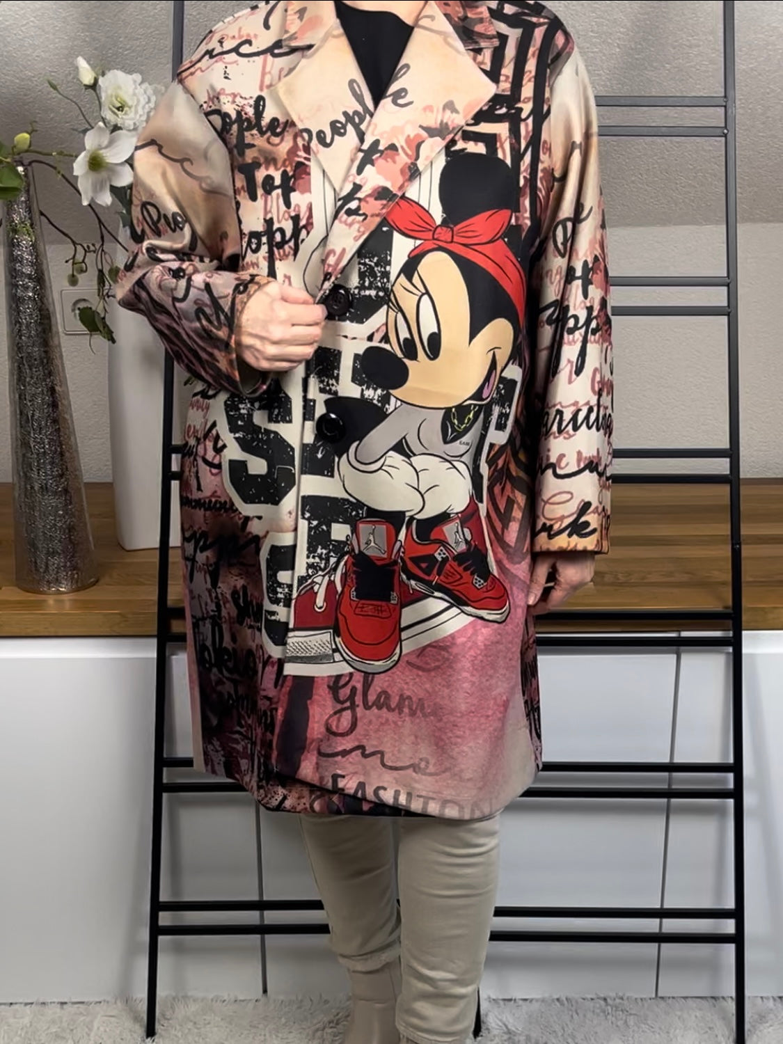 Frontansicht des „Mickey - Mouse“ Oversize-Mantels aus Velour-Optik mit 50 % Wollanteil, deutlich sichtbarem buntem Mickey-Maus-Motiv auf der Vorderseite, praktischen Taschen und schwarzen Knöpfen zum Schließen, in rot-bunt