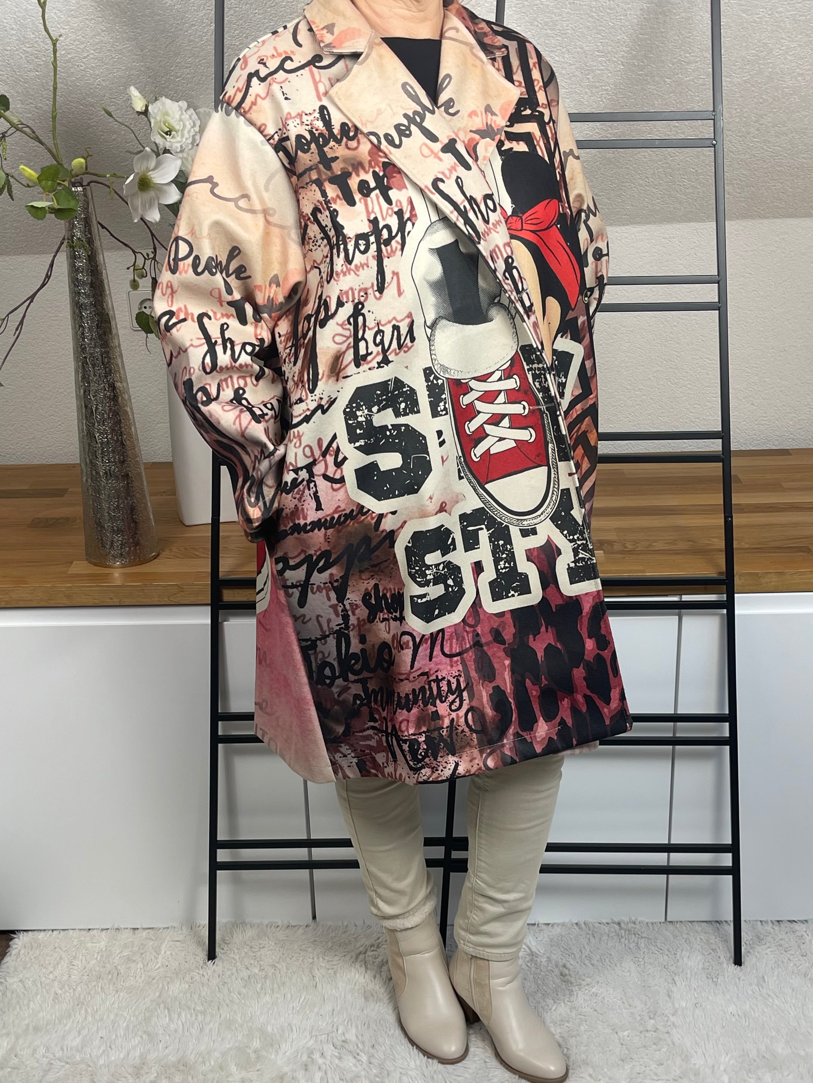 Detaillierte rechte Seitenansicht des „Mickey - Mouse“Oversize-Mantels aus Velour-Optik mit 50 % Wollanteil, buntem Mickey-Maus-Motiv, seitlicher Tasche und schwarzen Knöpfen zum Schließen, in rot-bunt