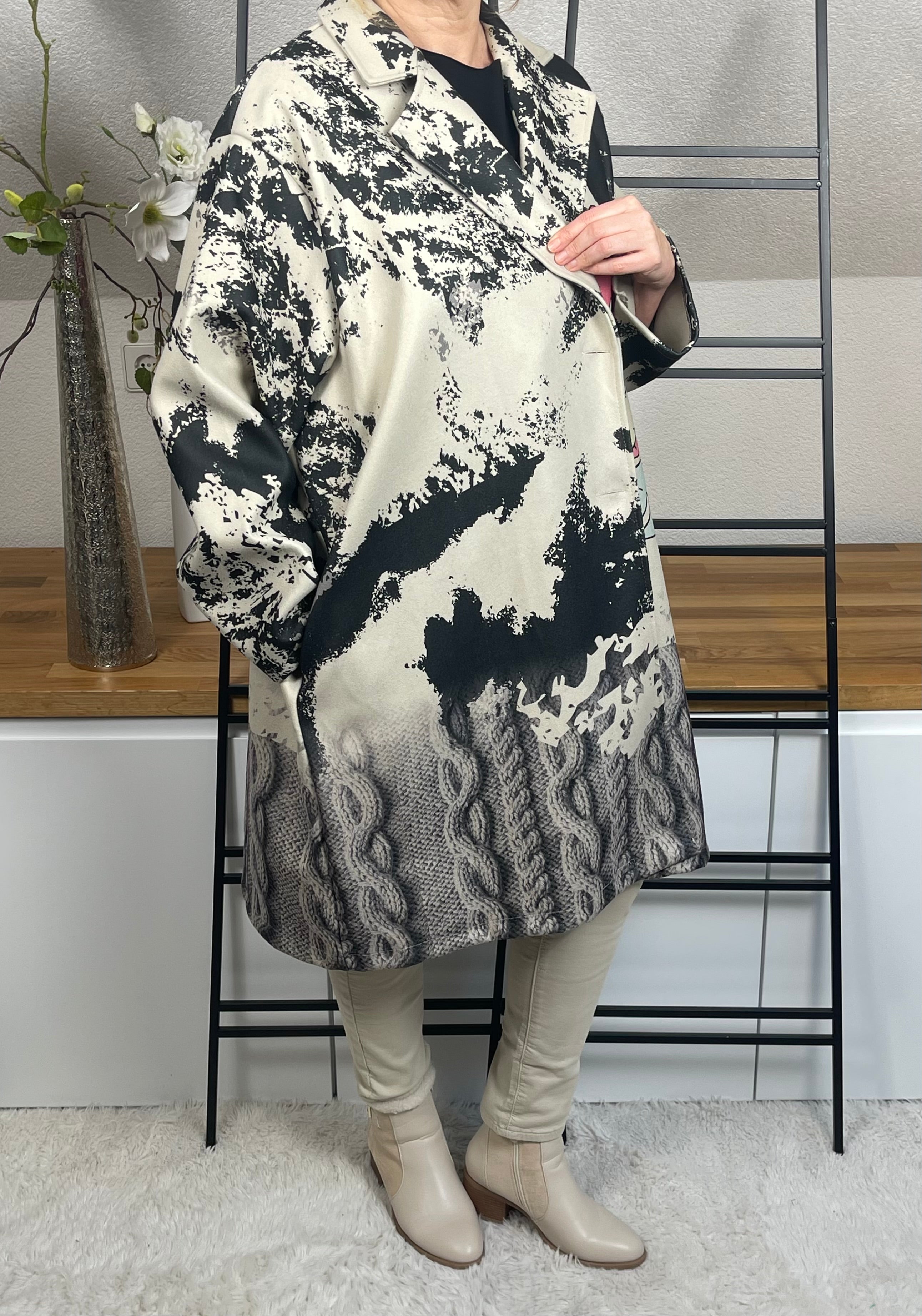 Rechte Seite des „Mickey - Mouse“Oversize-Mantels aus Velour-Optik mit 50 % Wollanteil, buntem Mickey-Maus-Motiv, praktischen Taschen und schwarzen Knöpfen zum Schließen, in grau-schwarz-bunt